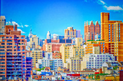 Buildings in city against blue sky