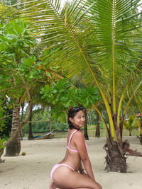 Portrait of young woman with palm tree