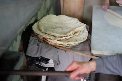 Cropped hands working with bread in kitchen