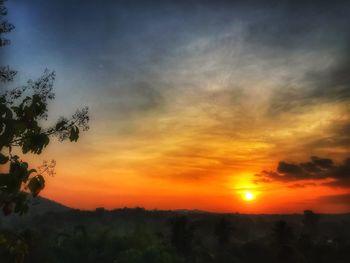 Scenic view of silhouette landscape against orange sky