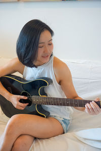 Midsection of a woman playing guitar
