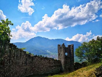 Old ruins by building against sky