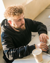 Portrait of young man drinking coffee at home