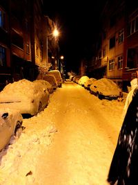 Snow covered illuminated road at night