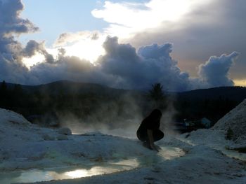 Woman on snowcapped mountain against sky