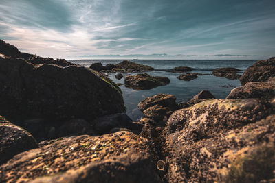 Rocks on beach against sky