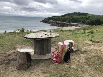 View of wooden posts on beach against sky