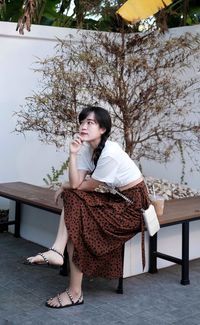 Portrait of young woman sitting on bench