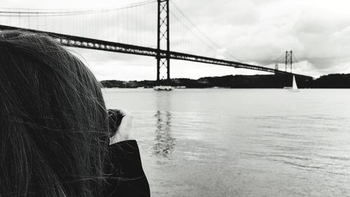 Rear view of woman standing on suspension bridge