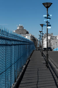 Street amidst buildings against clear blue sky