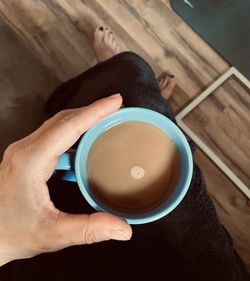 High angle view of hand holding coffee cup