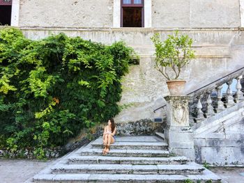 Woman sitting on steps against building