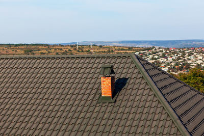 Chimney at the metal tile roof . rooftop of rural house