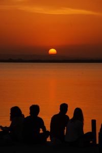 Silhouette people at beach during sunset