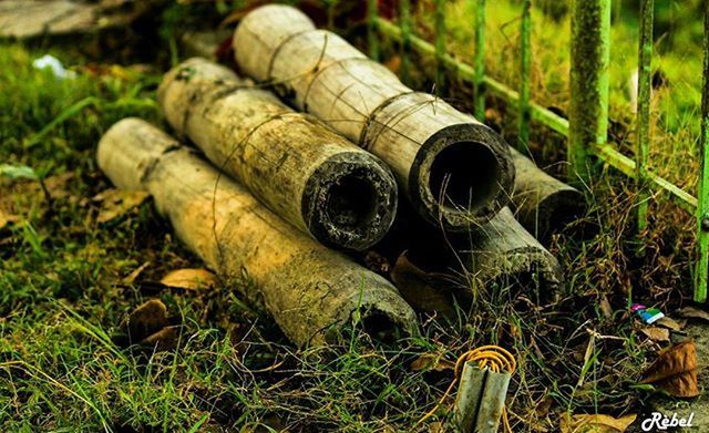 grass, field, close-up, metal, abundance, still life, day, equipment, outdoors, large group of objects, green color, no people, variation, work tool, abandoned, rusty, selective focus, stack, old, high angle view