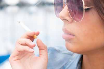 Close-up portrait of boy holding cigarette