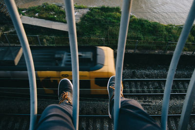 Low section of man sitting on railing