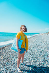 Portrait of young woman standing on beach