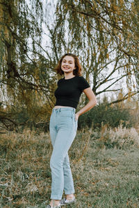 Portrait of smiling young woman standing in forest