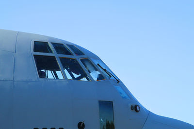 Low angle view of airplane against clear blue sky