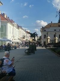 People on street against buildings in city