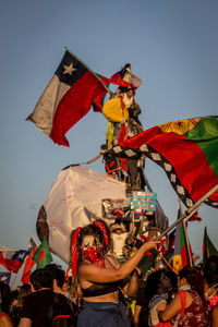 Low angle view of people on flags against sky