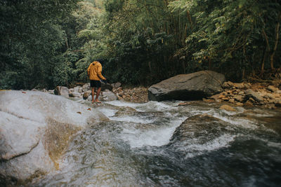 Full length of man on rocks in forest