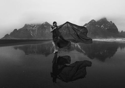 Elegant lady wrapped with chiffon on beach monochrome scenic photography