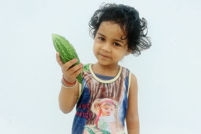 Cute girl holding ice cream standing against white background