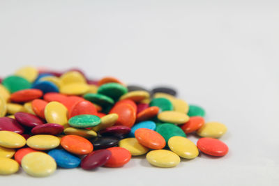 Close-up of multi colored candies against white background