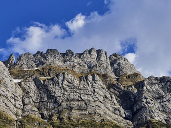 Low angle view of rocky mountain against sky