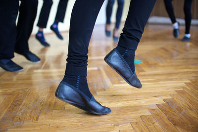 Low section of woman dancing on hardwood floor