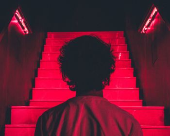 Rear view of man with red umbrella