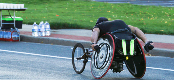 Rear view of man riding motorcycle on road