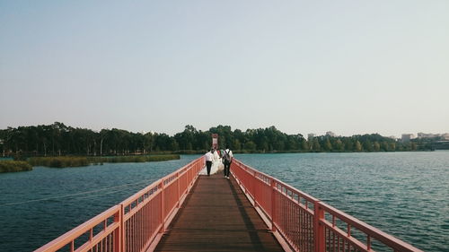 Rear view of woman standing on pier