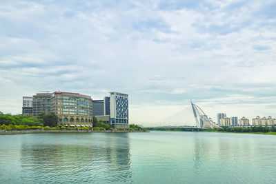 River by buildings against sky in city