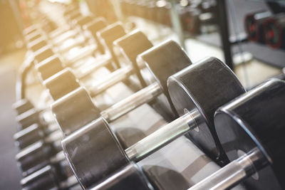 Close-up of dumbbells on rack at gym