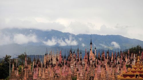 Stupas at shrine against mountain against sky