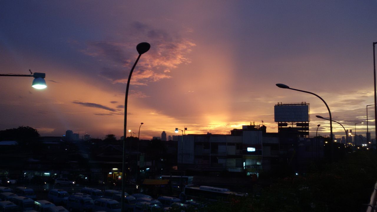 sunset, building exterior, architecture, built structure, city, sky, street light, illuminated, orange color, cityscape, silhouette, cloud - sky, lighting equipment, dusk, building, city life, outdoors, sun, no people, car