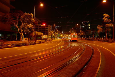 Illuminated light trails on road in city at night