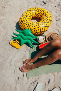 Low section of woman standing on sand at beach