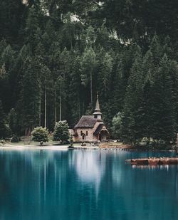 Scenic view of lake by building against trees