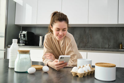 Young woman using mobile phone at home