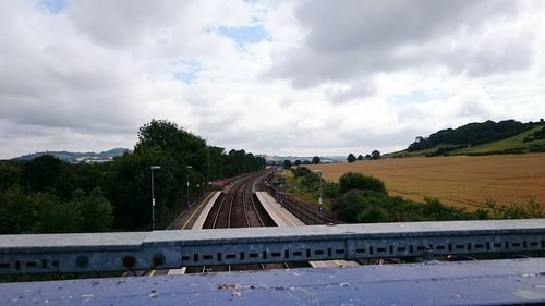 Road by trees against sky