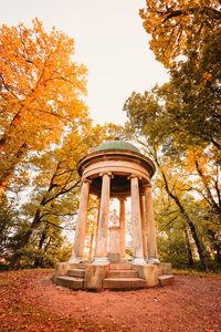 Low angle view of cross against sky during autumn