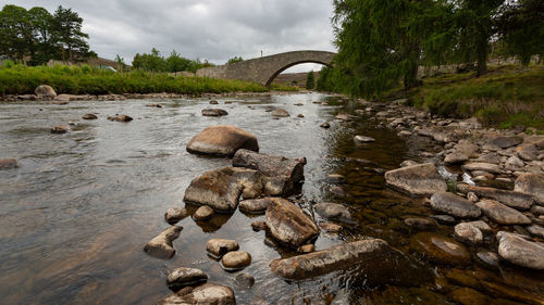 Stone bridge over river against sky