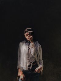 Young man looking away against black background