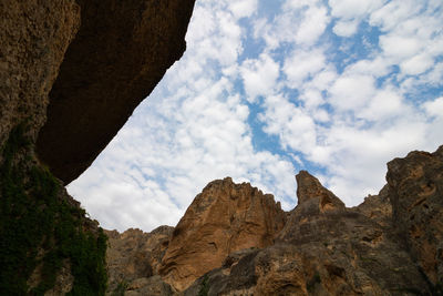 Low angle view of mountain against cloudy sky