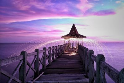 Pier over sea against sky during sunset