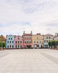 Houses by street in town against sky